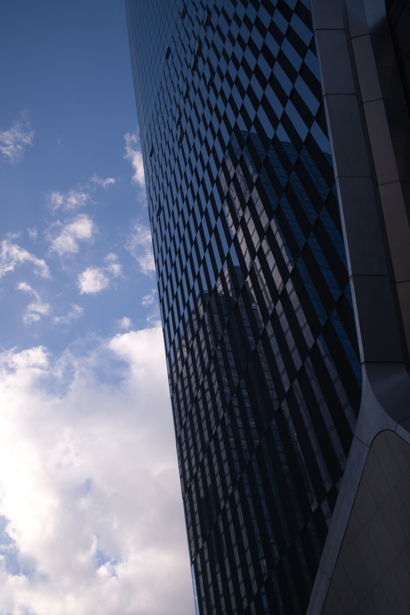 A geometric glass skyscraper against a blue sky