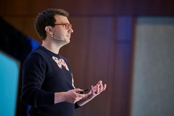 Matt speaking on stage at a conference